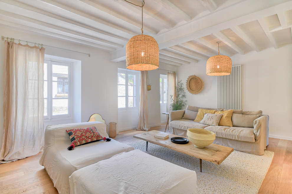 Foto di un soggiorno country aperto con pareti bianche, pavimento in legno massello medio, pavimento marrone e travi a vista