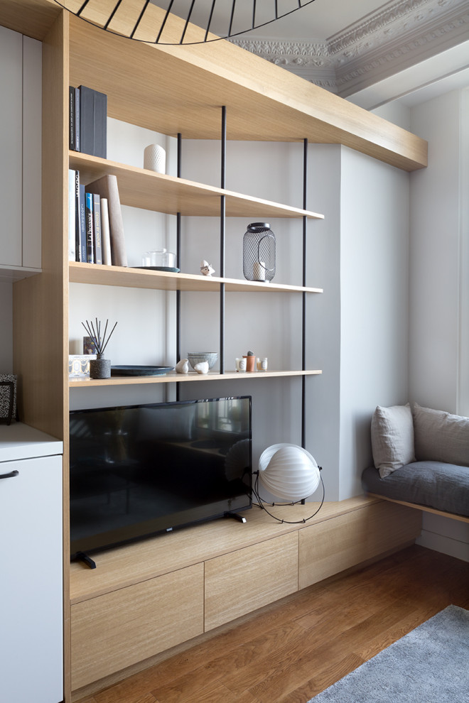 Esempio di un piccolo soggiorno scandinavo chiuso con libreria, pareti bianche e pavimento beige
