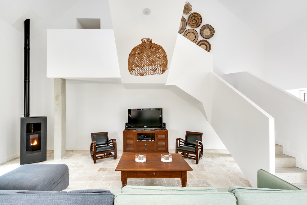 Cette image montre un grand salon bohème ouvert avec une salle de réception, un mur blanc, un sol en marbre, un poêle à bois, un téléviseur indépendant et un sol beige.