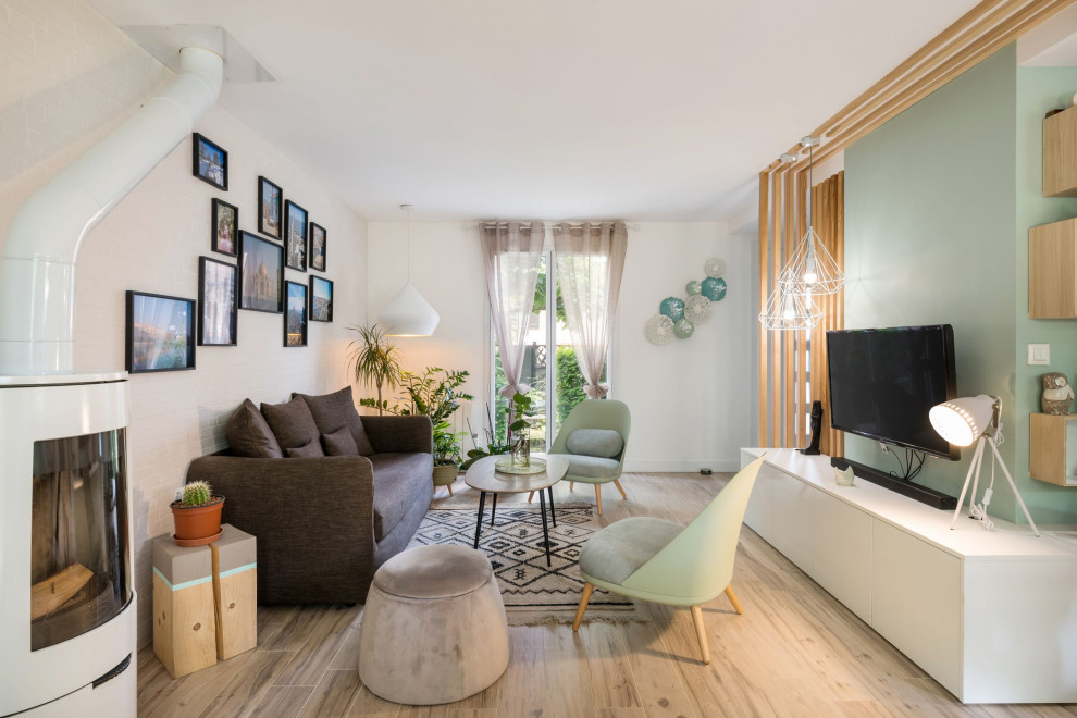 Foto di un piccolo soggiorno nordico aperto con pareti verdi, pavimento con piastrelle in ceramica, stufa a legna, TV a parete e pavimento beige