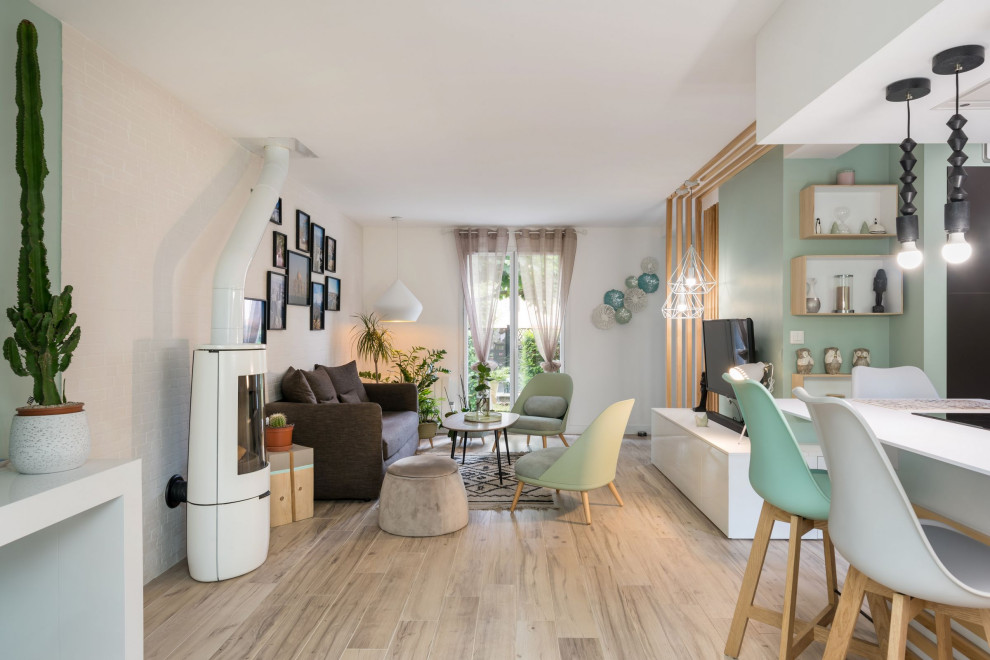 Immagine di un piccolo soggiorno scandinavo aperto con pareti verdi, pavimento con piastrelle in ceramica, stufa a legna, TV a parete e pavimento beige