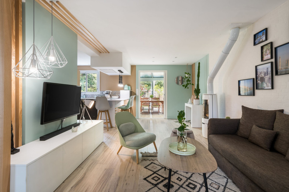 Idee per un piccolo soggiorno nordico aperto con pareti verdi, pavimento con piastrelle in ceramica, stufa a legna, TV a parete e pavimento beige