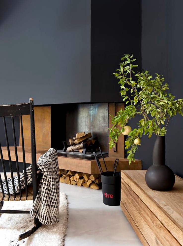 На фото: открытая гостиная комната среднего размера в современном стиле с черными стенами, бетонным полом и стандартным камином без телевизора