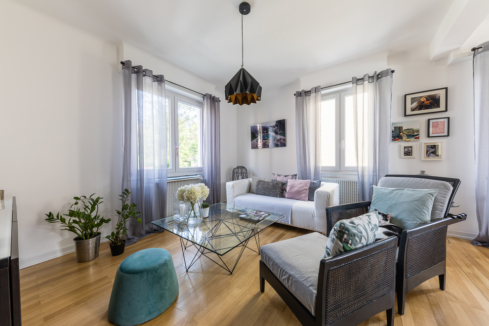 Cette image montre un salon design avec un mur blanc et parquet clair.