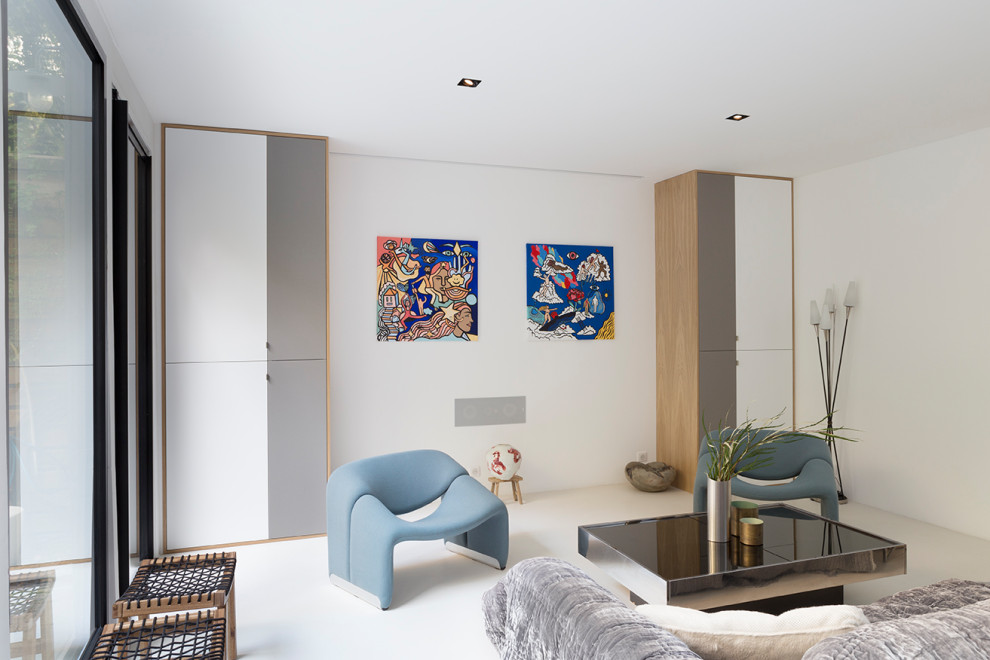 Стильный дизайн: открытая гостиная комната среднего размера в современном стиле с музыкальной комнатой, бежевыми стенами, бетонным полом, скрытым телевизором и белым полом - последний тренд