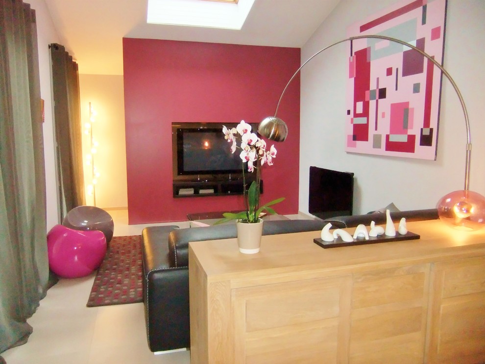 Источник вдохновения для домашнего уюта: открытая гостиная комната среднего размера в современном стиле с с книжными шкафами и полками, розовыми стенами, полом из ламината, мультимедийным центром и серым полом