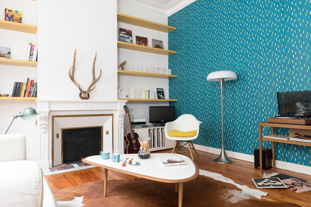 Inspiration pour un salon nordique de taille moyenne et fermé avec un mur bleu, un sol en bois brun, une cheminée standard, un manteau de cheminée en plâtre et un téléviseur indépendant.