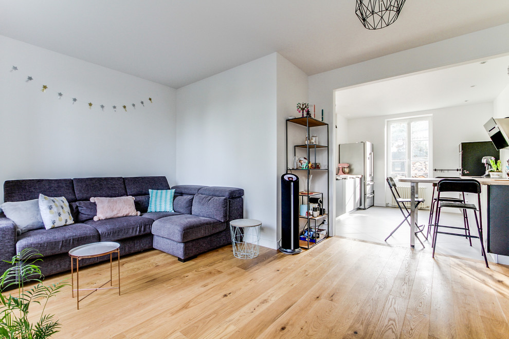 Mittelgroßes, Offenes Skandinavisches Wohnzimmer mit weißer Wandfarbe, Sperrholzboden und Eckkamin in Paris