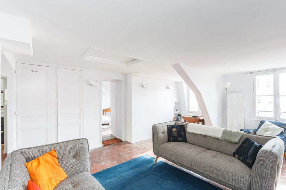 Cette image montre un salon minimaliste de taille moyenne et fermé avec un mur blanc, tomettes au sol, aucune cheminée, un téléviseur indépendant et un sol rouge.