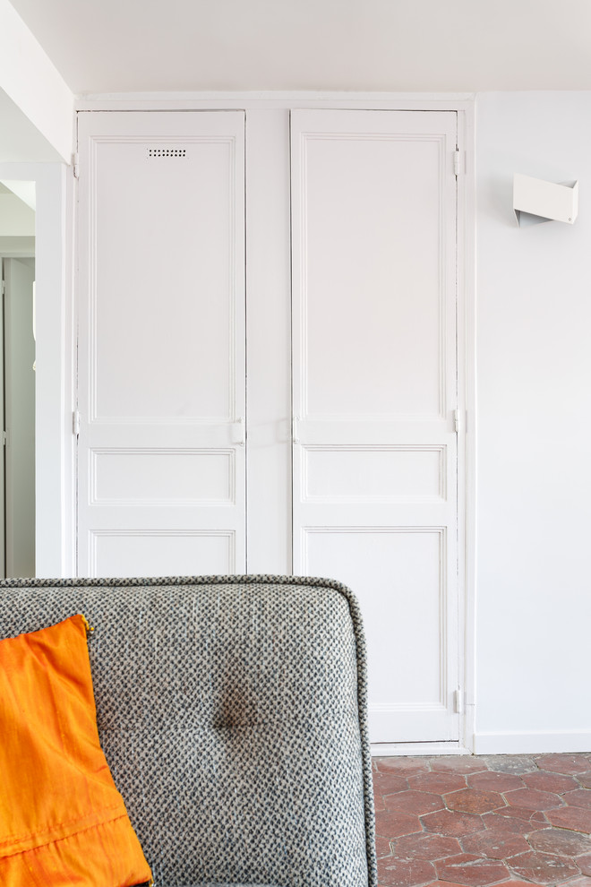 Mittelgroßes, Abgetrenntes Modernes Wohnzimmer ohne Kamin mit weißer Wandfarbe, Terrakottaboden, freistehendem TV und rotem Boden in Sonstige