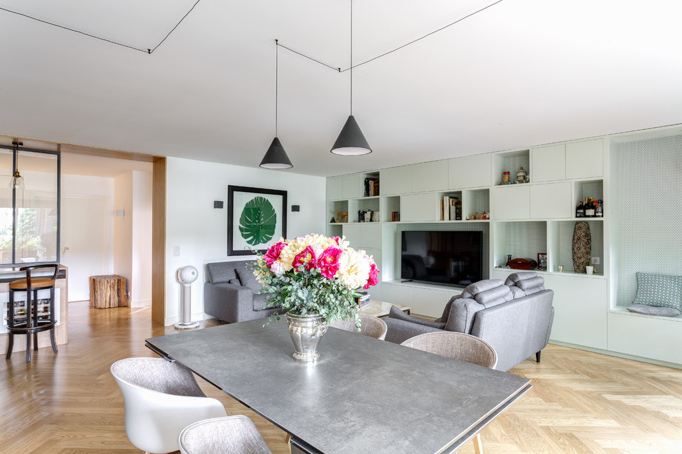 Imagen de salón abierto nórdico grande sin chimenea con paredes blancas, suelo de madera clara, pared multimedia y suelo beige