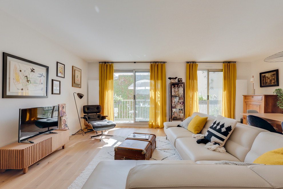 Imagen de salón para visitas abierto actual de tamaño medio con paredes blancas, suelo de madera clara, televisor independiente y suelo beige
