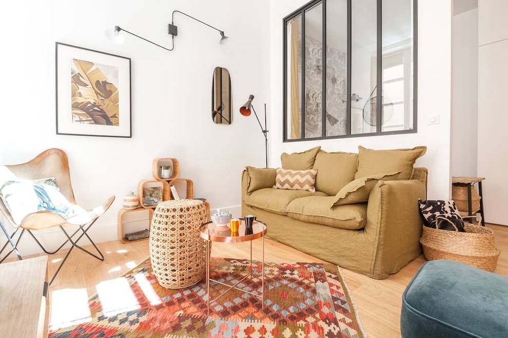 Kleines, Offenes Wohnzimmer mit gelber Wandfarbe, hellem Holzboden, freistehendem TV und beigem Boden in Lyon