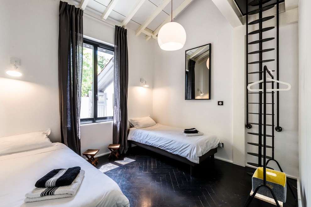 Immagine di un soggiorno minimal con pareti bianche, pavimento in legno verniciato e pavimento nero