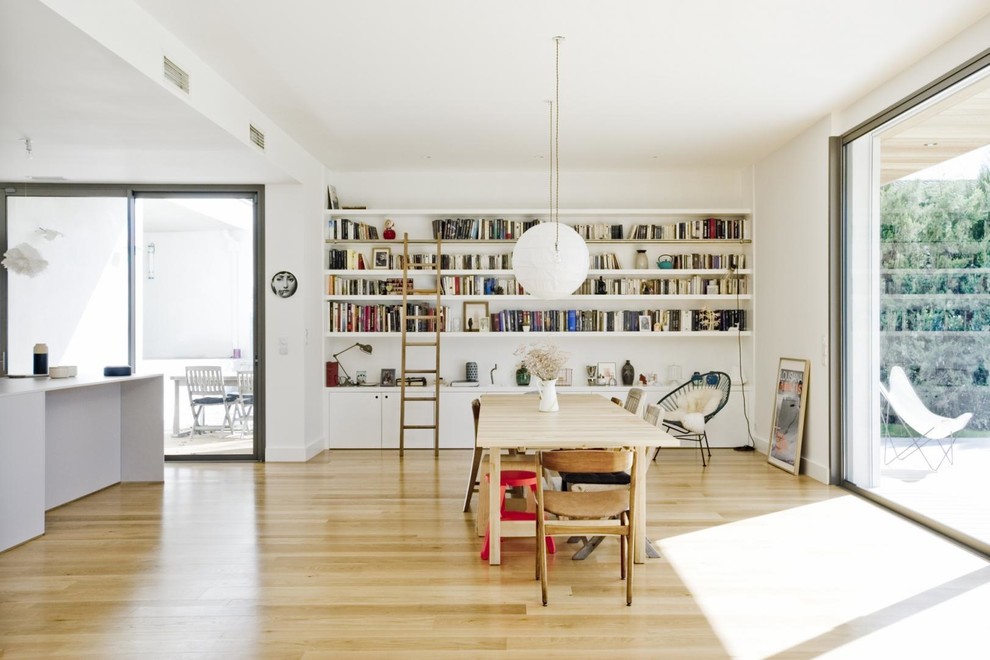 Immagine di un grande soggiorno contemporaneo aperto con libreria, pareti bianche e pavimento marrone