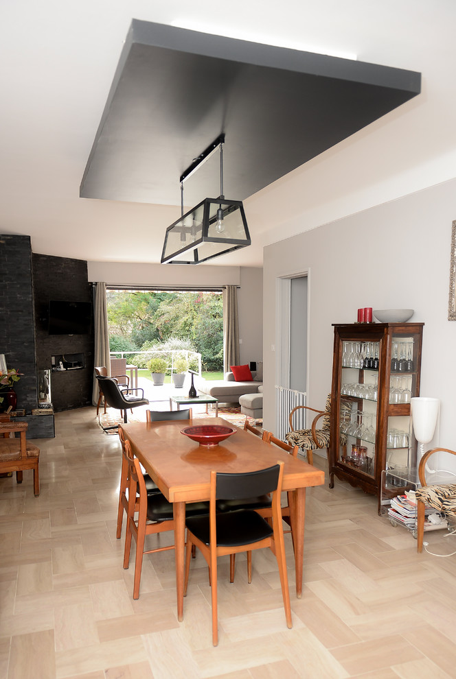 Cette image montre une salle à manger ouverte sur le salon minimaliste de taille moyenne avec un mur blanc, sol en stratifié et un sol marron.