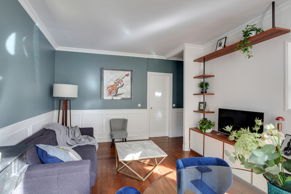 Idées déco pour un salon classique de taille moyenne et ouvert avec un mur bleu, parquet foncé, une cheminée standard, un manteau de cheminée en pierre, un téléviseur indépendant et un sol marron.