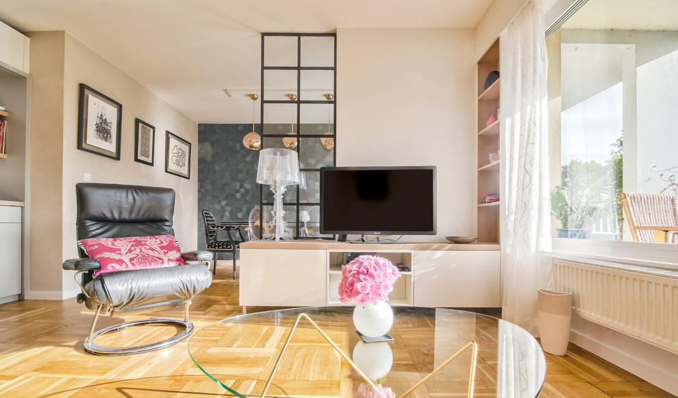 Ejemplo de salón ecléctico de tamaño medio con paredes beige, suelo de madera clara y televisor independiente