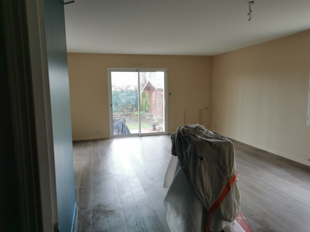 This is an example of a medium sized modern formal open plan living room in Nantes with beige walls, laminate floors, a wood burning stove, a metal fireplace surround, a wall mounted tv and grey floors.
