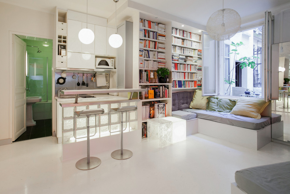 Idées déco pour un salon contemporain ouvert avec une bibliothèque ou un coin lecture, un mur blanc et un sol blanc.