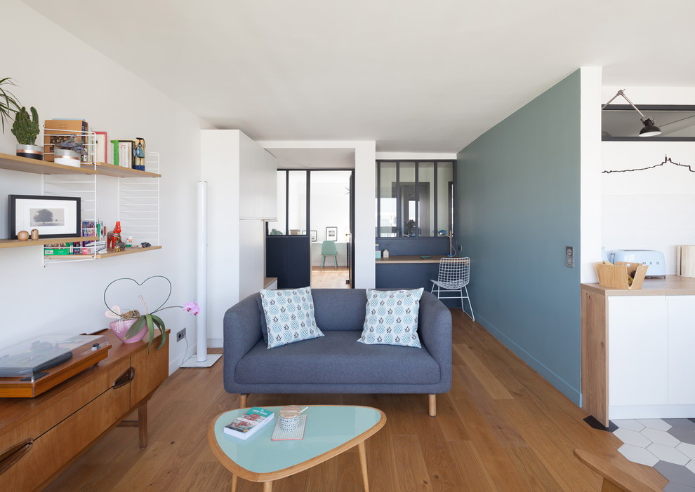 Imagen de salón abierto escandinavo de tamaño medio sin televisor con paredes azules y suelo de madera clara