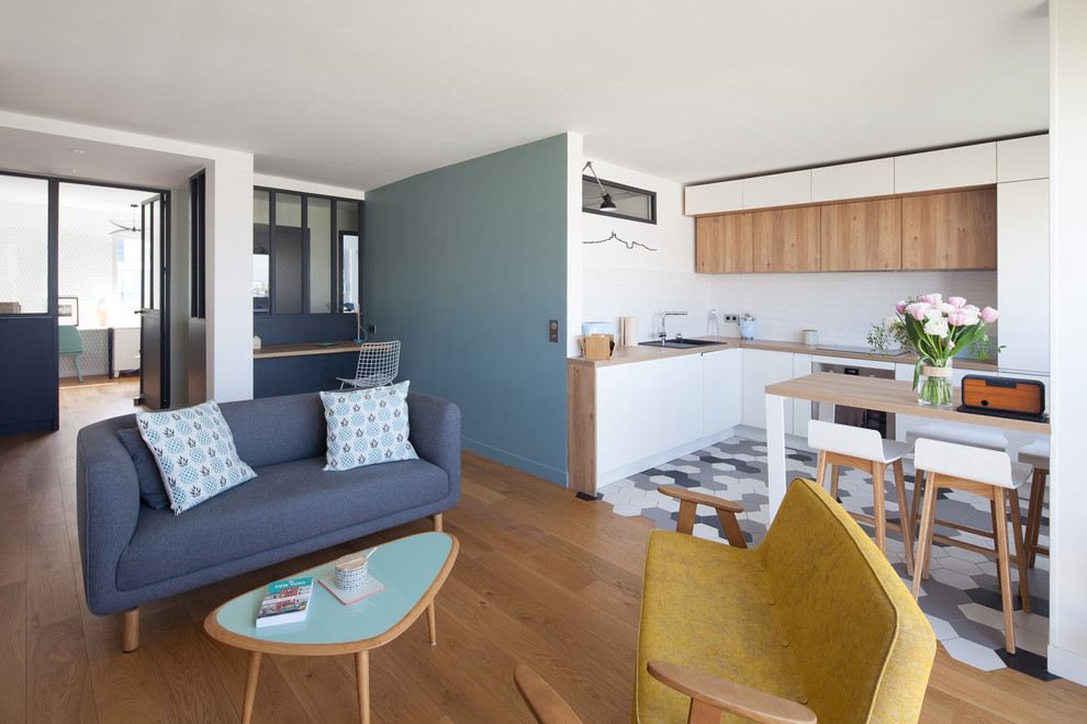 Diseño de salón abierto nórdico de tamaño medio sin televisor con paredes azules y suelo de madera clara
