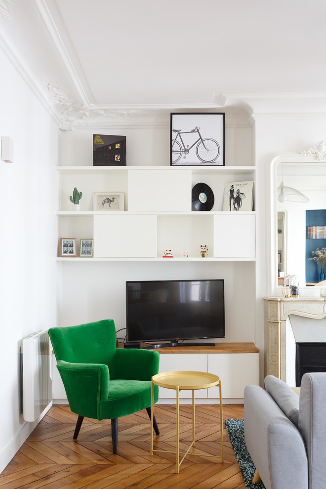 Mittelgroßes, Offenes Modernes Wohnzimmer mit weißer Wandfarbe, braunem Holzboden, Kamin, Kaminumrandung aus Stein, freistehendem TV und braunem Boden in Paris