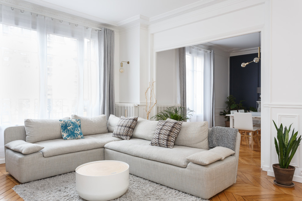 Inspiration pour un salon minimaliste de taille moyenne et ouvert avec un mur blanc, un sol en bois brun, une cheminée standard, un manteau de cheminée en pierre, un téléviseur indépendant et un sol marron.