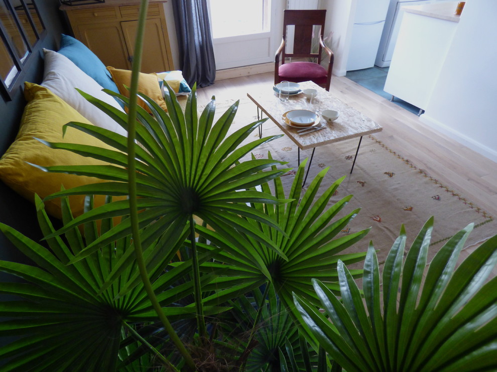 Mittelgroßes, Offenes Eklektisches Wohnzimmer mit grüner Wandfarbe, hellem Holzboden und braunem Boden in Paris