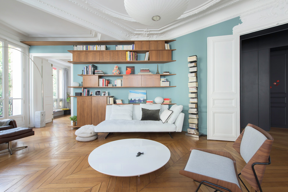 Foto di un grande soggiorno design chiuso con libreria, pareti blu, pavimento in legno massello medio, nessun camino e nessuna TV