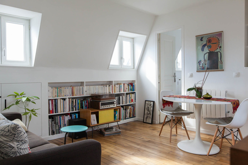Ejemplo de biblioteca en casa abierta contemporánea pequeña sin chimenea y televisor con paredes blancas y suelo de madera en tonos medios