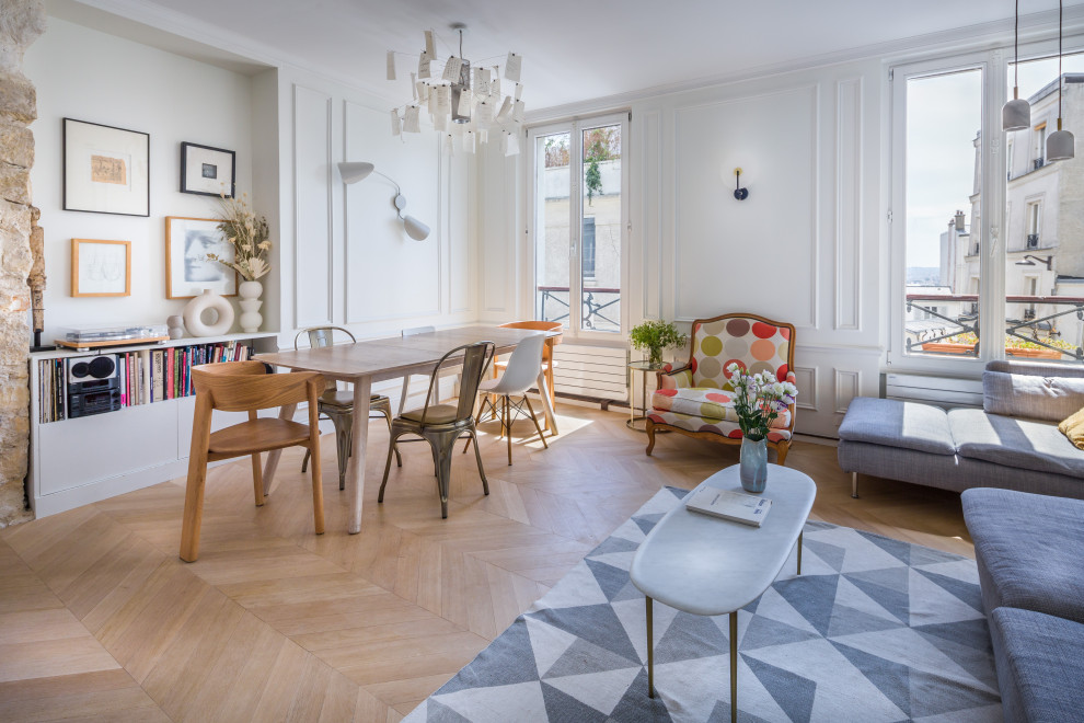 Idee per un soggiorno boho chic aperto con pareti bianche, parquet chiaro, pavimento beige e pannellatura