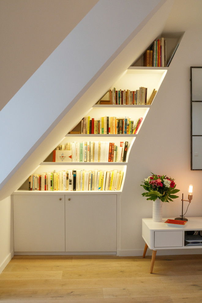 Ejemplo de biblioteca en casa abierta romántica de tamaño medio con paredes blancas y suelo de madera clara