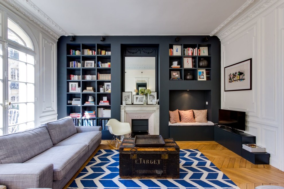 Modernes Wohnzimmer mit weißer Wandfarbe, braunem Holzboden, Kamin, freistehendem TV und braunem Boden in Paris