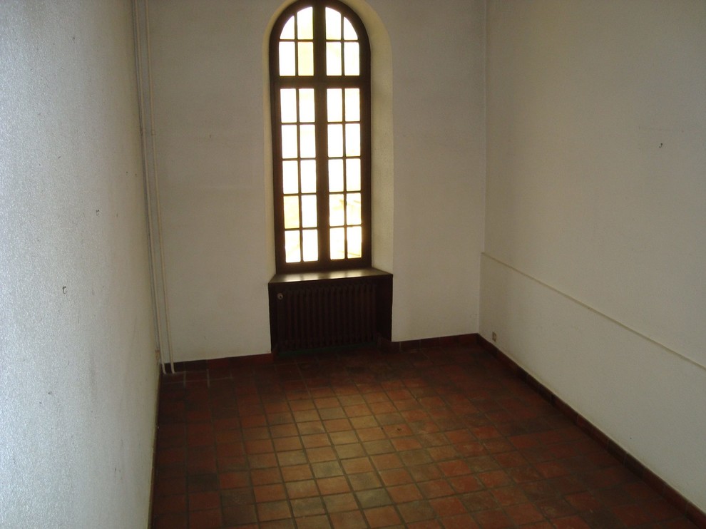 Immagine di un soggiorno eclettico di medie dimensioni con pavimento in terracotta e pavimento marrone