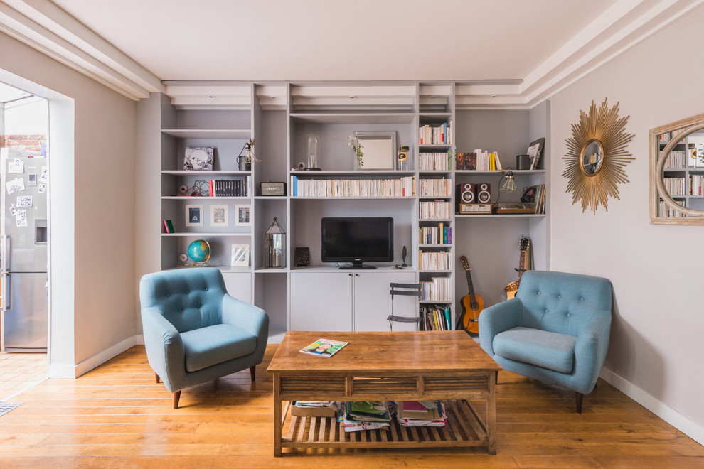 Идея дизайна: изолированная гостиная комната в стиле неоклассика (современная классика) с с книжными шкафами и полками, серыми стенами, паркетным полом среднего тона и отдельно стоящим телевизором без камина