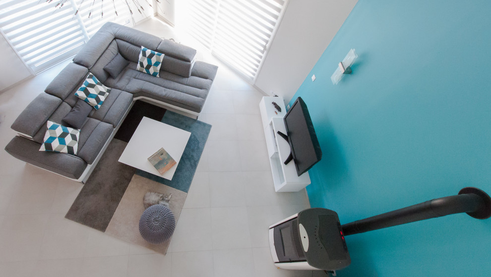 Immagine di un grande soggiorno contemporaneo aperto con libreria, pareti blu, pavimento con piastrelle in ceramica e stufa a legna