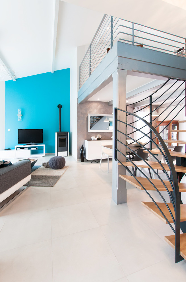 Idee per un grande soggiorno design aperto con libreria, pareti blu, pavimento con piastrelle in ceramica, stufa a legna e nessuna TV