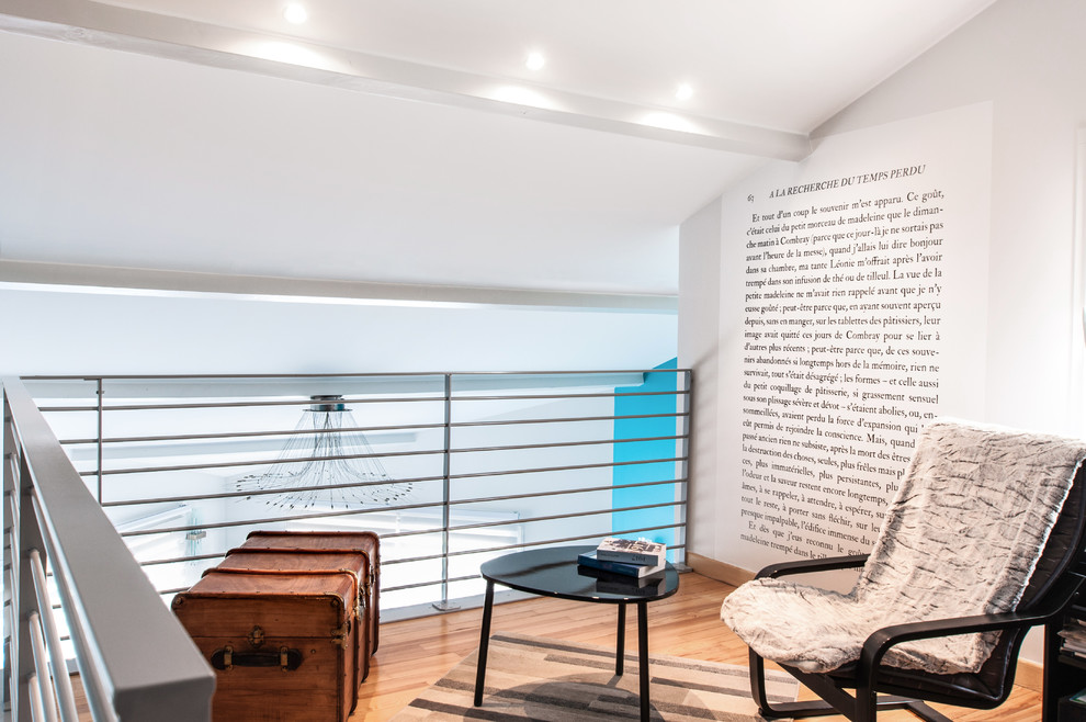 Exemple d'un grand salon tendance ouvert avec une bibliothèque ou un coin lecture, un mur bleu, parquet clair, un poêle à bois et un téléviseur indépendant.