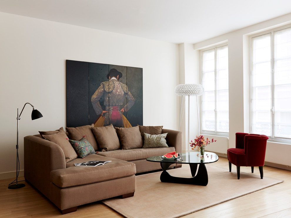 This is an example of a medium sized contemporary open plan living room in Paris with white walls and light hardwood flooring.