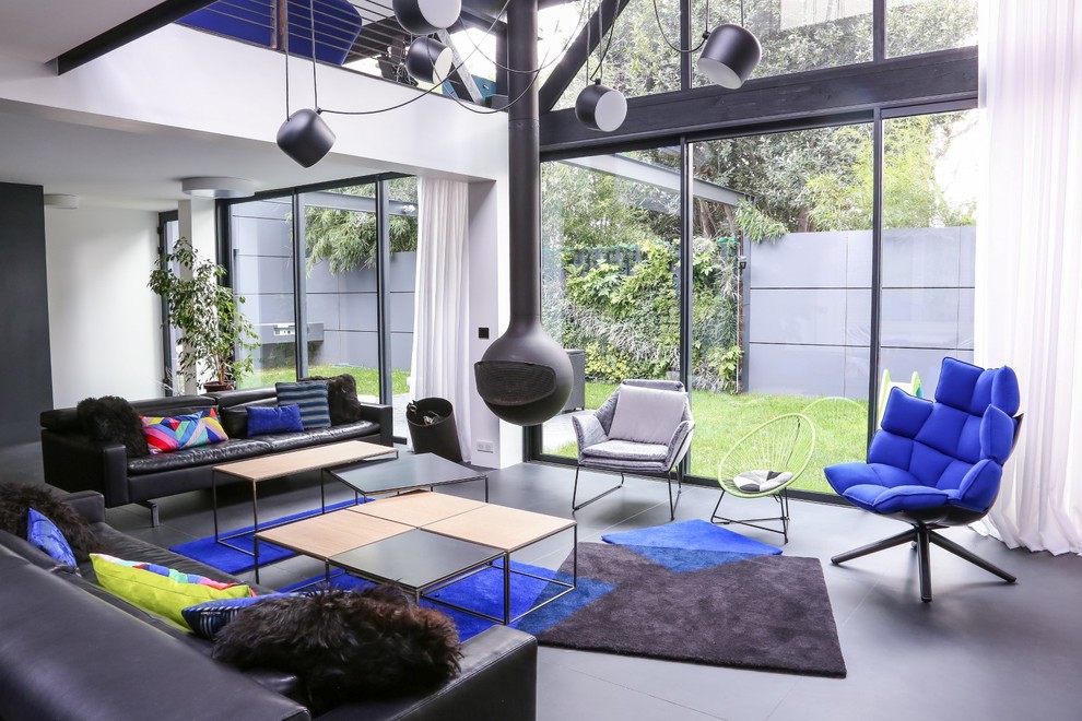Fernseherloses, Mittelgroßes, Offenes Modernes Wohnzimmer mit weißer Wandfarbe, Betonboden und Hängekamin in Nantes