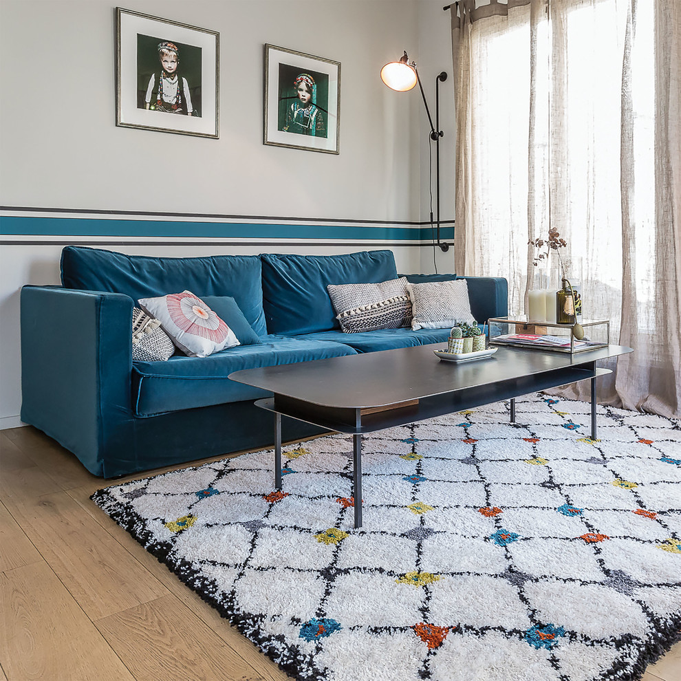 Идея дизайна: большая гостиная комната в скандинавском стиле с белыми стенами, светлым паркетным полом и синим диваном без камина, телевизора