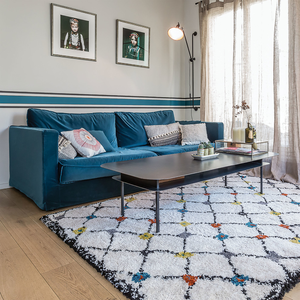 This is an example of a large scandi living room in Paris with white walls, light hardwood flooring, no fireplace and no tv.