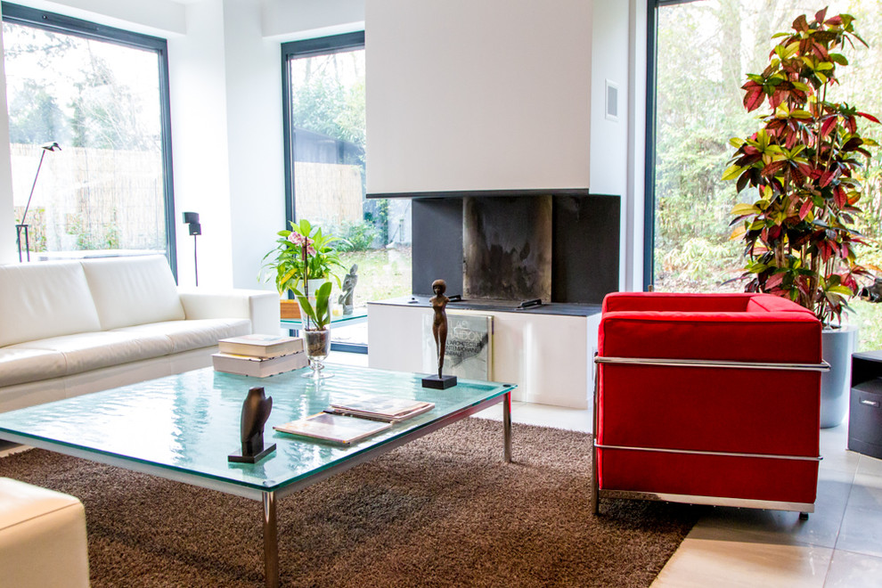 Стильный дизайн: открытая гостиная комната среднего размера в стиле модернизм с белыми стенами, полом из керамической плитки, стандартным камином, фасадом камина из металла и скрытым телевизором - последний тренд