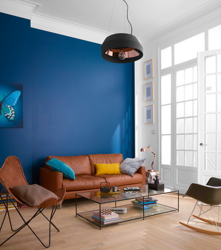 Diseño de salón cerrado actual de tamaño medio sin televisor con paredes azules y suelo de madera clara