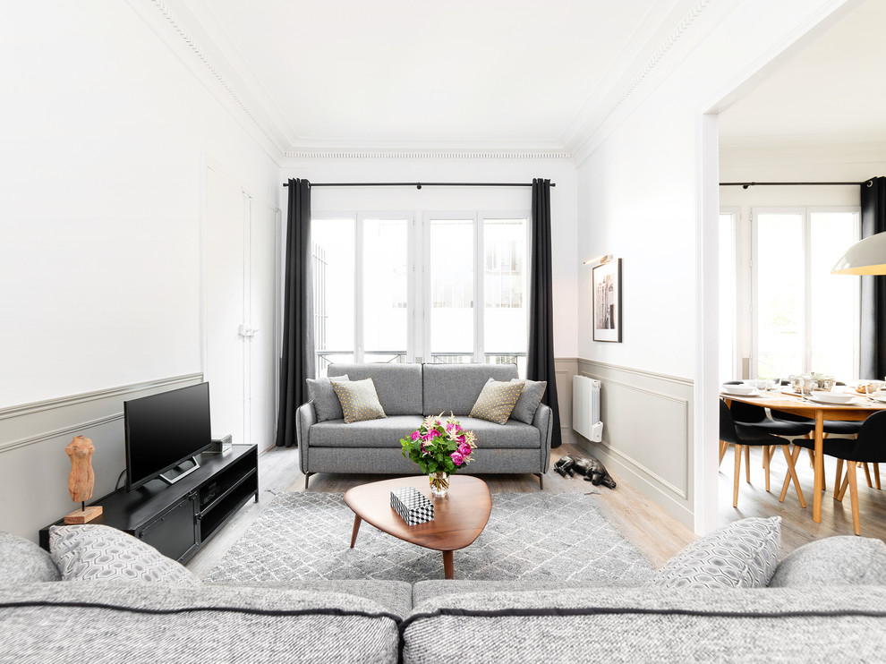 Esempio di un soggiorno contemporaneo chiuso con pareti bianche, parquet chiaro, nessun camino, TV a parete e pavimento beige