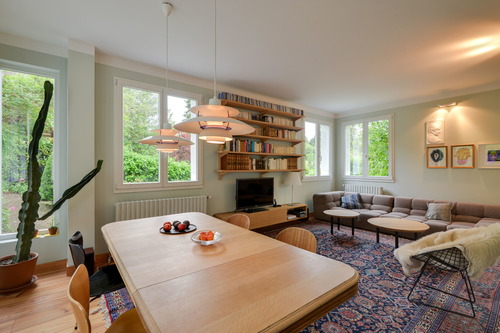 Esempio di un soggiorno scandinavo di medie dimensioni e aperto con sala formale, pareti verdi, parquet chiaro, nessun camino e TV autoportante