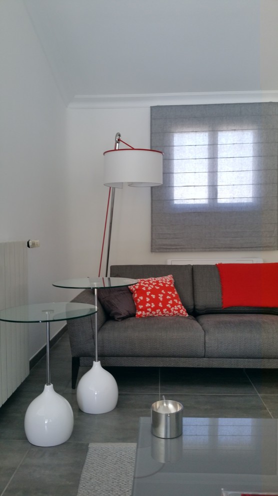 Imagen de salón cerrado contemporáneo de tamaño medio con paredes blancas, suelo de baldosas de cerámica y suelo gris
