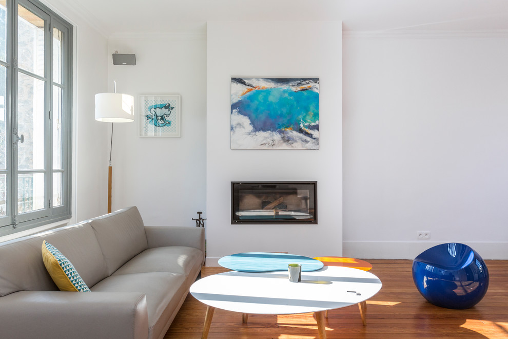 Immagine di un soggiorno chic aperto e di medie dimensioni con pareti bianche, pavimento in legno massello medio, camino lineare Ribbon, TV autoportante e pavimento marrone