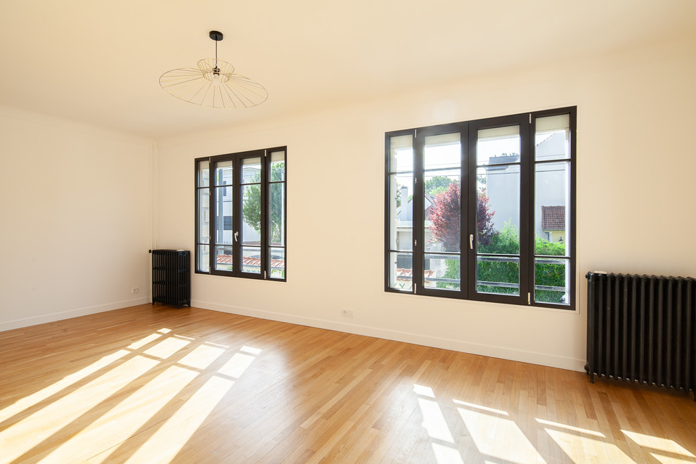 Esempio di un soggiorno classico di medie dimensioni e chiuso con pareti bianche, parquet chiaro e pavimento marrone